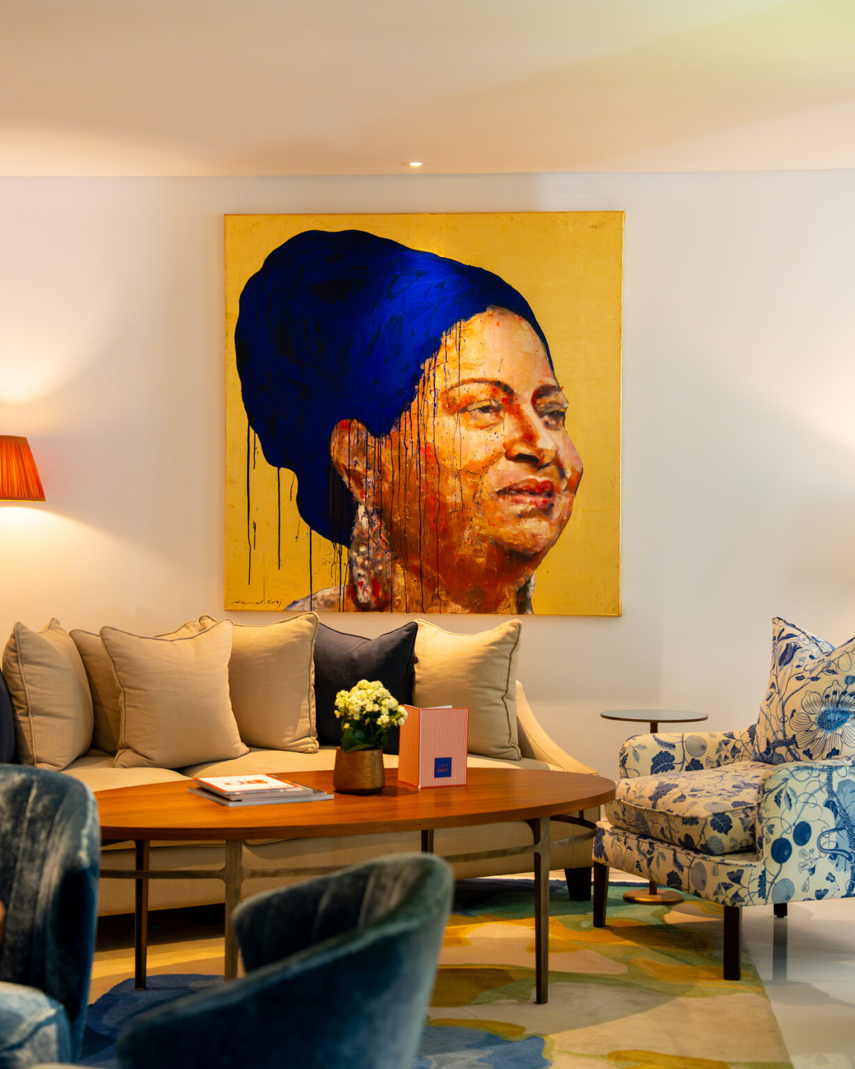 The lobby at The Merchant House, Manama, with contemporary Bahraini paintings above a cream sofa and blue velvet armchairs